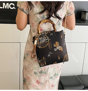 Detail of black lace bag with bamboo handle paired with traditional cheongsam dress