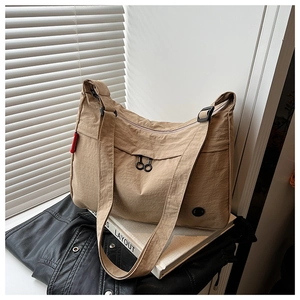 Khaki nylon crossbody bag detail with dual zippers and adjustable wide strap
