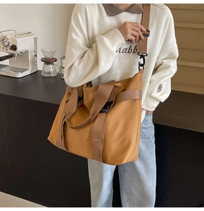 Close-up of brown canvas tote bag with adjustable strap in a modern cafe setting