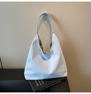 Macro shot of light blue PU leather tote bag showing fine vertical grain and tan lining