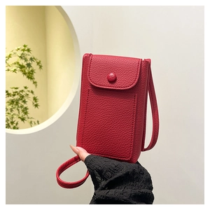Detail of red pebbled leather mini crossbody bag featuring classic flap and fine stitching