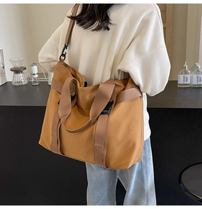 Large mustard yellow canvas tote bag with brown straps styled on a coffee shop bar