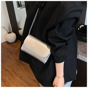 Gedetailleerde weergave van de zilveren metallic finish en slanke schouderband op de tas