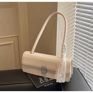 Dettaglio della borsa beige in twill con nastro in pizzo e fibbia in strass argento