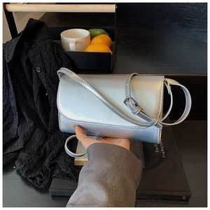 Detail van een zilveren metallic crossbodytas met een verstelbare smalle schouderriem
