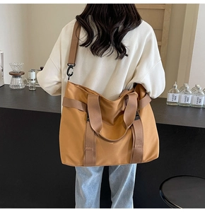 Detail of caramel brown canvas travel tote bag with reinforced handles and shoulder strap