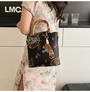 Detail of Chinese style handbag with bamboo handle, floral patterns and metal chain strap