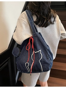 Large dark blue denim tote bag with cat embroidery and a small coin purse on a model