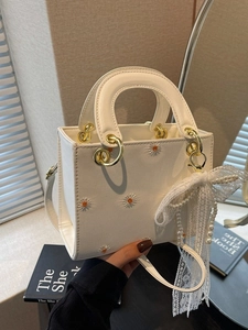 White daisy embroidered handbag with gold hardware and pearl bow accessory for women