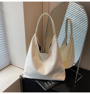 Detailed close-up of white Hobo shoulder bag with subtle ripple texture and wide strap