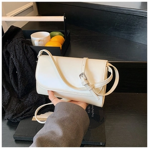 Detail van de minimalistische gebroken witte rechthoekige crossbodytas met zilveren gesp