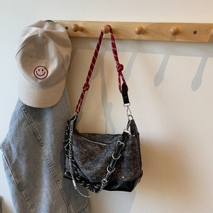 Detail of glittery fabric tote with red rope strap and silver chain hardware accents