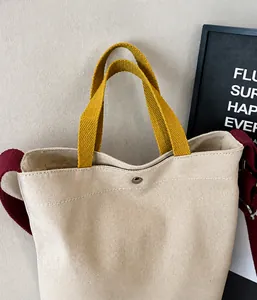 Détail du sac fourre-tout en toile bicolore avec fermoir magnétique et anses