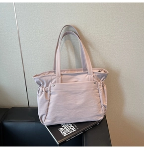 Détail d'un sac cabas en nylon violet clair avec des plis latéraux et des clous argentés