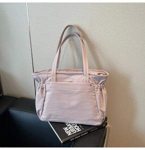 Détail du grand cabas en nylon rose clair avec plis latéraux et rivets sur cuir noir