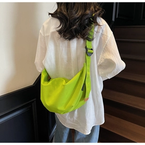 Model wearing a neon green canvas crescent bag showing body proportions and fit