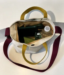 Vue détaillée de la grande capacité intérieure du sac cabas en toile avec bouton pression