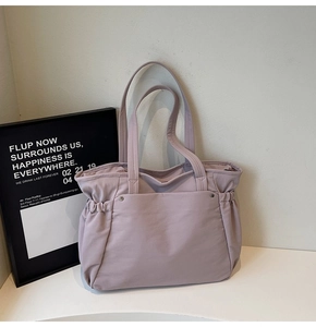 Détail du sac cabas lilas avec plis latéraux et grande poche frontale à rivets en métal
