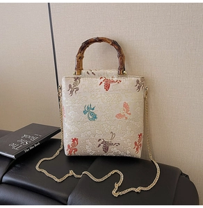 Detailed view of the fish embroidery and bamboo handle on the cream lace handbag