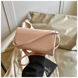 Detail van een nude roze glanzende crossbodytas met klep en smalle schouderriem