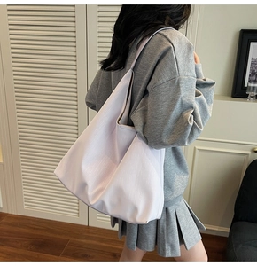 Close-up of a large pale purple tote bag with vertical stripes shown on a model