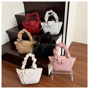 Detailed row of pleated handle handbags in six colors on wooden steps with tassels