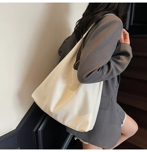 Detail of high-quality synthetic leather texture on a cream-colored hobo tote bag