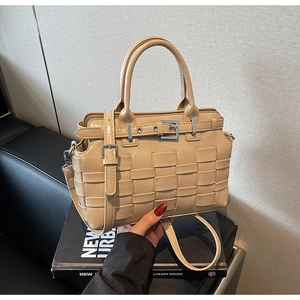 Dettaglio della borsa a secchiello intrecciata beige con cinturino in pelle