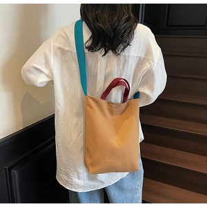 Détail du sac seau en toile avec fermeture magnétique et bandoulière de couleur contrastée