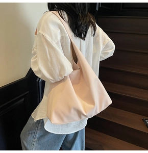Pale pink glossy leather tote bag shown on model for stylish everyday commuting use