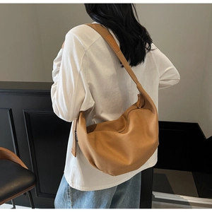 Detail view of the brown canvas hobo bag with adjustable strap and woven brand label