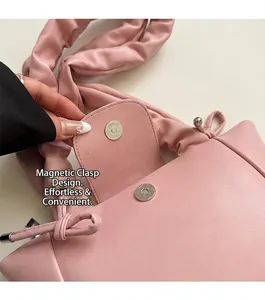 Detail view of the pink pleated handbag featuring a practical magnetic snap closure design