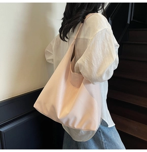 Close-up of pink oversized tote bag with glossy texture worn by model in minimalist setting