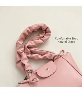 Detail of pink pleated wide shoulder strap and metal buckle on fashionable PU leather bag