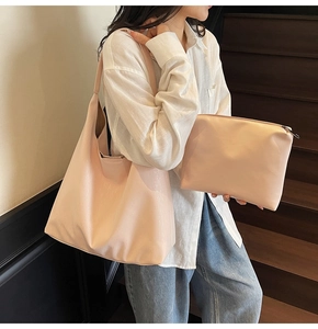 Pink faux leather tote bag and zipper pouch set shown on a model in a modern interior