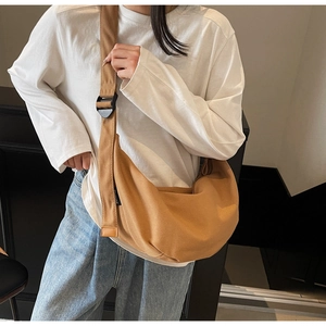 Detail of camel canvas crescent bag with wide adjustable shoulder strap and woven logo