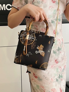 Elegant Chinese style embroidered handbag with bamboo handle and golden floral patterns