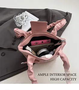 Top view of open pink pleated handbag showing spacious interior with daily essentials