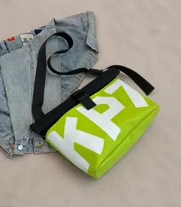 Detail of the neon green messenger bag with large lettering and adjustable strap