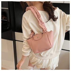 Detailed view of pink PU leather shoulder bag featuring pleated cloud-style strap and metal buckle