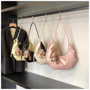 Detailed view of ruched crescent shoulder bags in four colors with bear charms