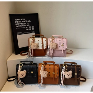 Detailed display of five colorful mini backpacks featuring monogram patterns and cute bear charms