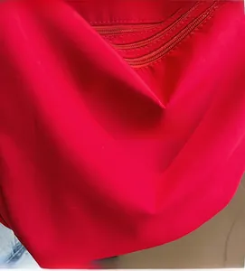 Close-up of red nylon fabric texture with high-quality zipper and stitching details