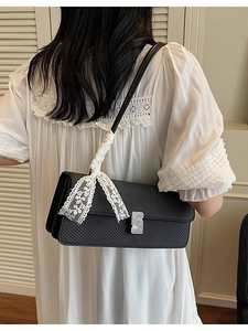 Elegante borsa a tracolla nera con finitura testurizzata, fibbia a S e fiocco in pizzo