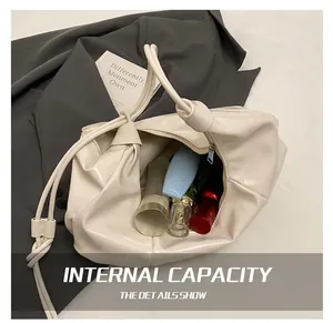 Detailed interior storage showing cosmetics inside cream pleated ruched cloud bag