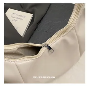 Macro shot of high-quality silver metal zipper and beige PU leather detail on tote bag