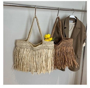 Détail d'un sac cabas tissé avec de longues franges en beige et marron bohème