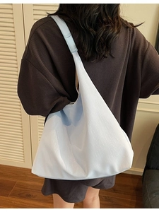 Light blue minimalist large capacity shoulder bag shown on model in cozy home setting