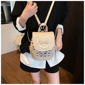 Detail of cream leather backpack with lace heart and black gingham bow accents