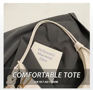 Detail of creamy white patent leather bag with a unique knot handle and metal hook closure
